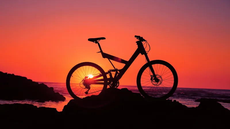 Bicycle silhouette wallpaper, Orange sunset, Seaside rocks