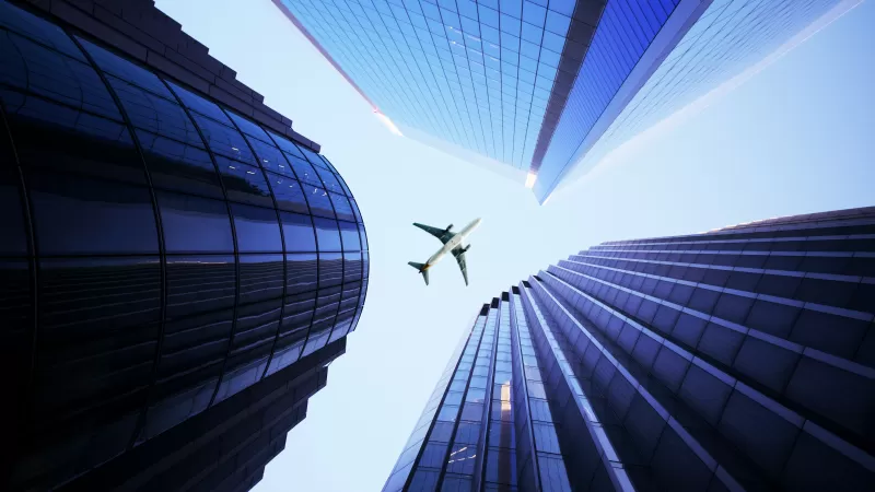 Airplane between skyscrapers wallpaper, Looking up, Blue glass