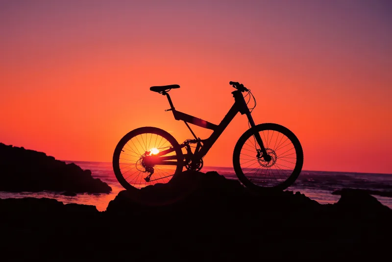 Bicycle silhouette wallpaper, Orange sunset, Seaside rocks