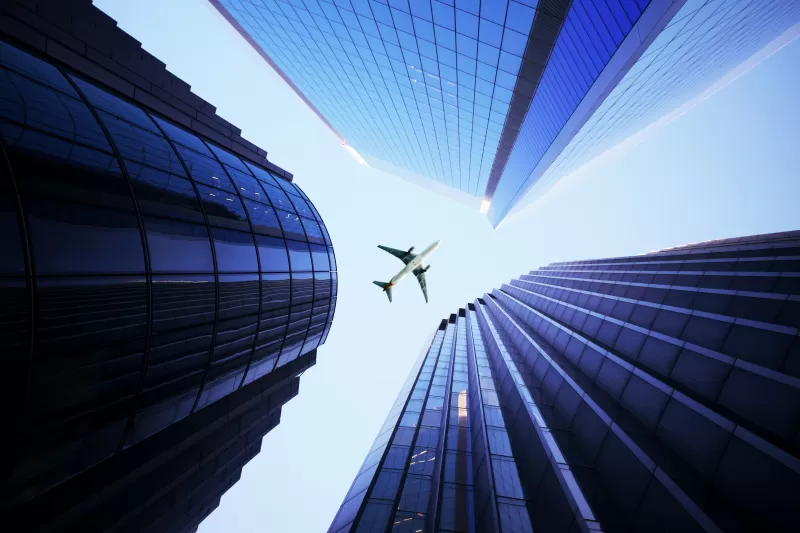 Airplane between skyscrapers wallpaper, Looking up, Blue glass